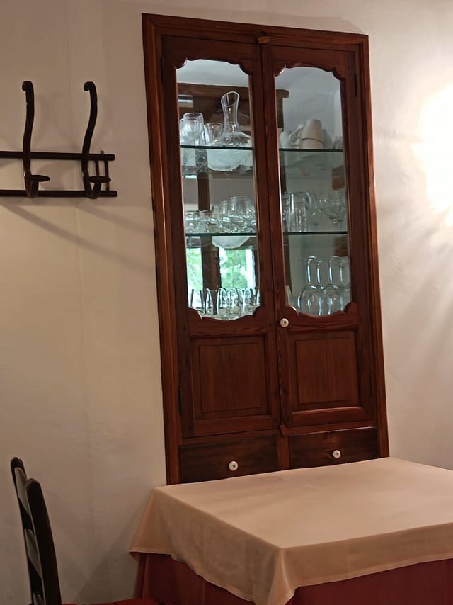 Armari de fusta antic amb cristalleria al menjador